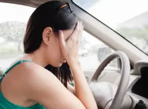 woman with her hands on her face after a car accident