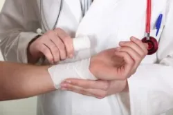 A doctor wrapping a bandage around a patient's wrist