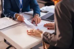 lawyer showing client where to sign a retainer