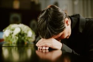 woman grieving over a casket