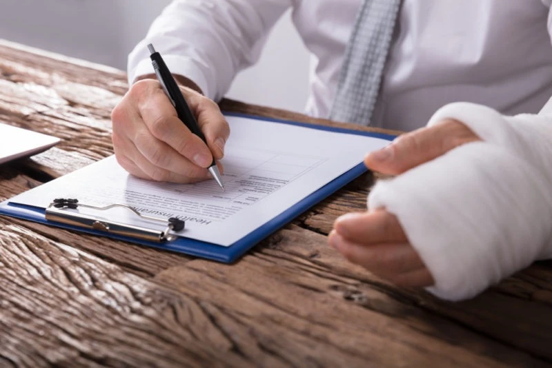 An injured employee signs a document.