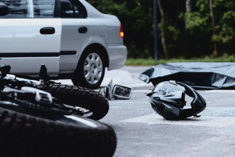 A motorcycle and helmet lie in the street after a collision until a Georgetown motorcycle accident lawyer arrives to preserve evidence. 