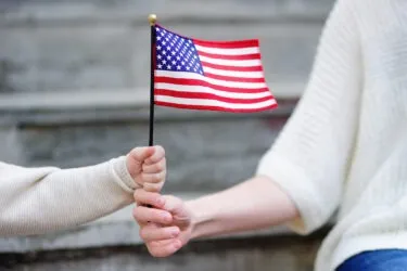 Woman and little child holding an American flag. Learn the common reasons for an RFE.