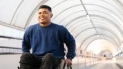 A young Black man rolls his wheelchair up a ramp while wondering: Can you get approved for disability on your first try?