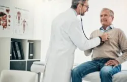 A male doctor uses a stethoscope to listen to the heart of an older man who is worried about what not to say to a disability doctor.