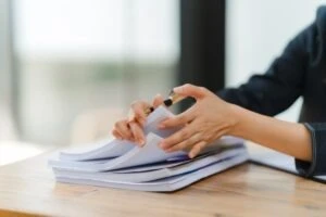 A woman with a stack of documents. A lawyer can answer questions like, “What is proof of disability documentation?”