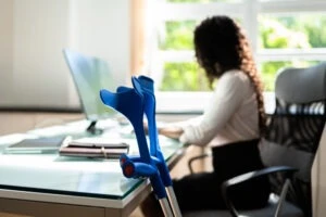 An injured woman at a computer wonders, “Can you work while applying for Social Security Disability?”