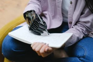 Amputated hand victim using a prosthetic hand to write