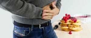 Man clenching his stomach from a foodborne illness