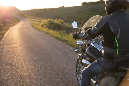 A motorcycle rider sits on a road preparing for a ride. A motorcycle lawyer can advise you on how to seek a settlement for damages in an accident.