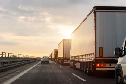 A car shares the road with commercial trucks. An attorney can lead your case for a truck accident settlement that covers your damages.