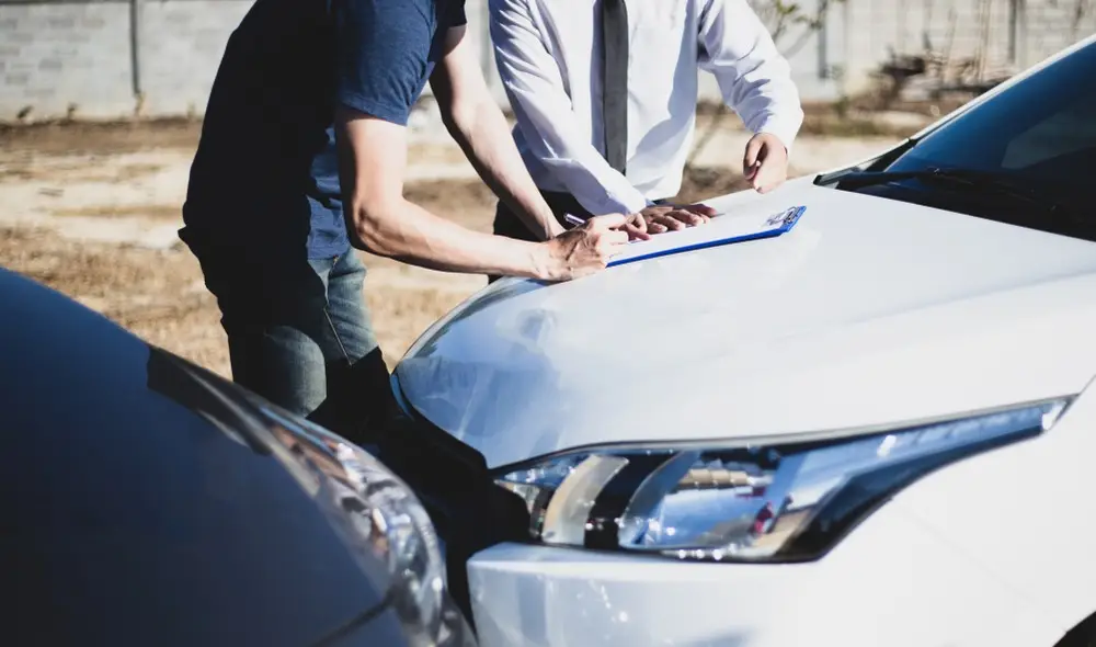 Two men are writing on a clipboard at what appears to be the scene of an accident where one car has rear-ended another. Rockpoint Legal Funding can provide lawsuit loans to cover your expenses during a lawsuit.