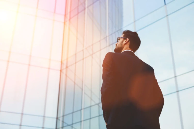 A man in a suit facing buildings determined to pursue a legal claim against a company by being supported by pre-settlement funding options