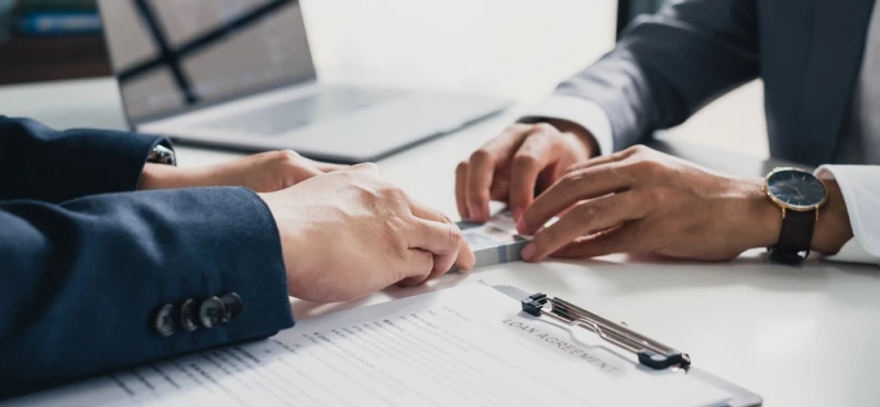 Closeup scene of hands giving pre-settlement funding money to man