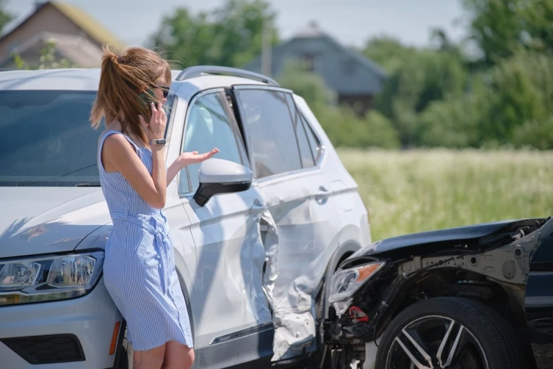 Concerned female driver talking on phone on side of road after car accident