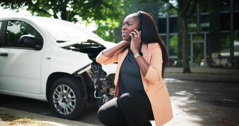 Woman talking by phone after car accident