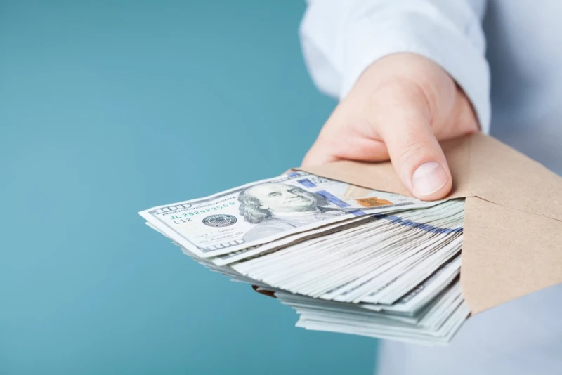 Man in white shirt handing Lawsuit Loan money in envelope