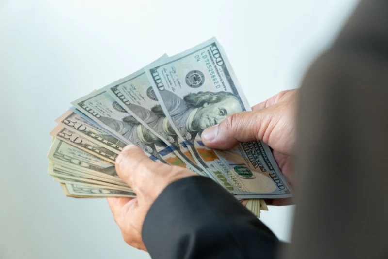 Man in suit holding Lawsuit Loan money