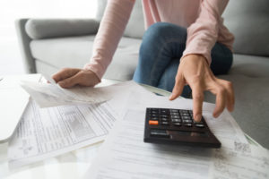 A woman calculates all of her bills and expenses.