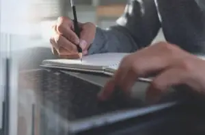 person taking notes on a computer