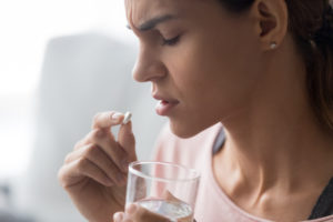 woman about to take a pill