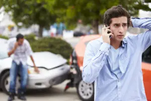 teenager on his cell phone after a car accident