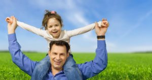 a child sitting on her fathers shoulders