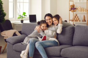 happy loving mother hugs daughters