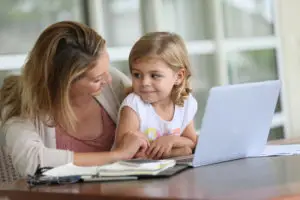 little girl looking at laptop with mom