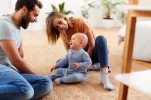 parents sitting on floor at home with baby