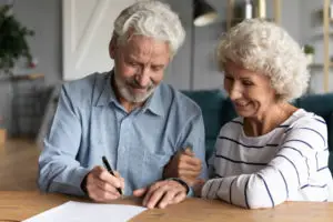 elderly couple signing loan paperwork