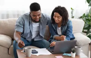 black couple happily reviewing their finances