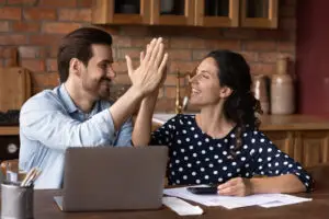 white couple high-fiving over money