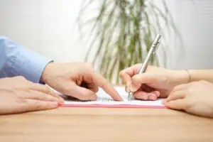lawyer directing client where to sign