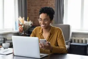 black woman happily checking bank statement