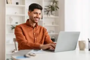 middle-eastern man happily checking account balance