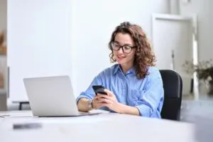 woman happily checking bank account on computer