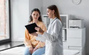 woman reviewing medical results on a device with her doctor
