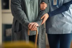 A nurse with an older man in a nursing home. You can contact a Duluth nursing home abuse lawyer to get help for your family.