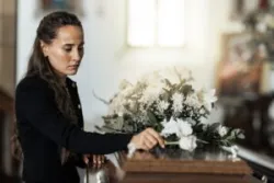 A grieving woman at a funeral. You can get support from a Duluth wrongful death lawyer after a deadly accident.