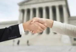 lawyer and client shaking hands in front of courthouse