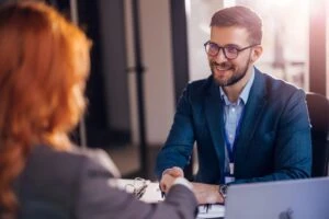 A male client smiling and shaking hands with his female lawyer after she discusses whether undocumented immigrants can sue for personal injury.