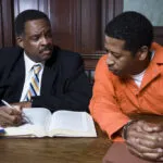 A criminal defense attorney and a client in Alpharetta, GA, review case law before a court hearing.