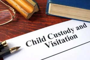 The words "child custody and visitation" appear on a piece of paper. You can deny visitation to a non-custodial parent in Georgia when there is a valid reason for it. A family lawyer can advise you of how to handle visitation changes.