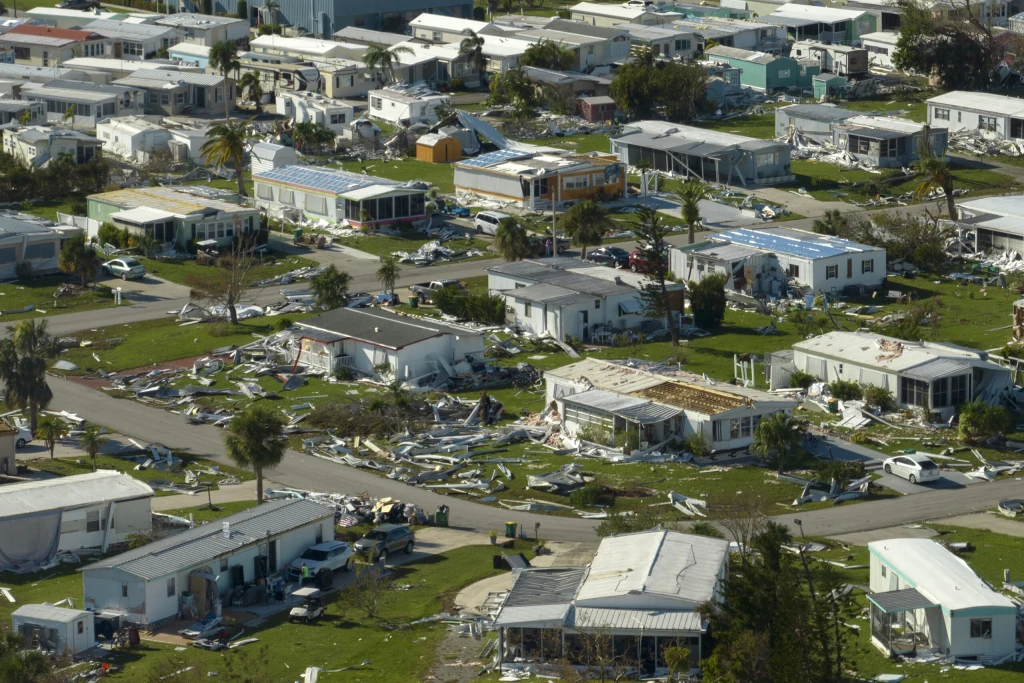 Collapsed and damaged mobile homes after hurricane swept through a residential area.
