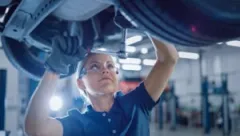 female-mechanic-works-on-lifted-car