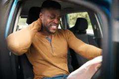 man-wincing-in-the-passenger-seat-after-an-accident