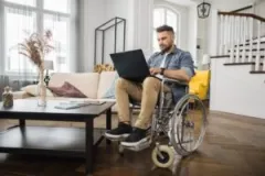 construction-injury-victim-in-wheelchair-chats-with-accident-lawyer-on computer