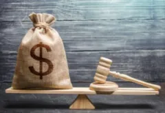 A scale weighing a bag of money and a gavel. Most construction accident lawyers get paid via contingency fees to make legal access and compensation fair and balanced.