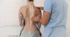 A medical professional examines a patient’s spine.